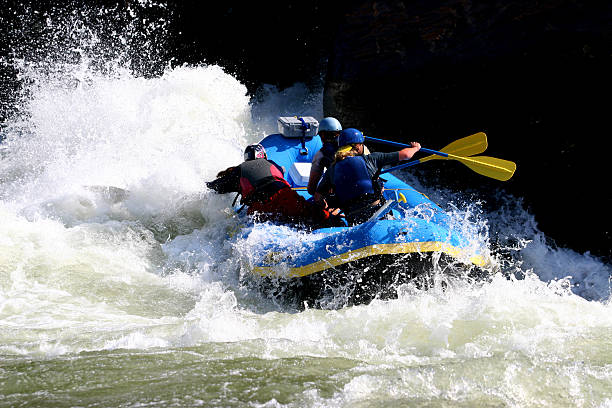 People running into a rock Whitewater Rafting